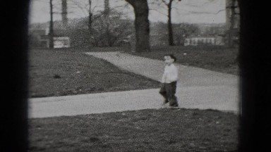 1948: a little boy running and trying to catch a white dove in the park