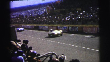 1955: men racing cars around a race car track as people watch LE MANS
