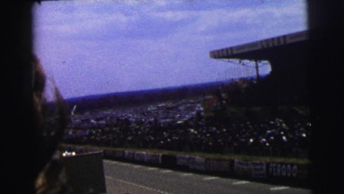 1955: people are attending a car race that has many spectators cheering and
