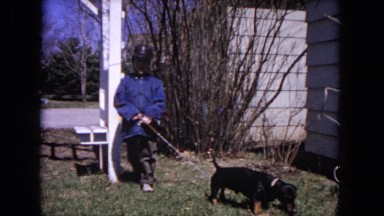 1964: cute little child takes his adorable small dog for a walk outside