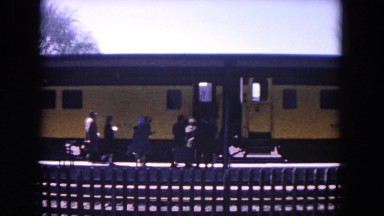 1964: people are walking into a train and then the train stars moving. EVANSTON