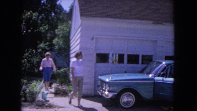 1964: two excited people going to the car for vacation trip EVANSTON, ILLINOIS