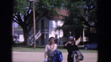 1964: two nicely dressed women walking through a neighborhood with hats, gloves