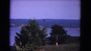 1964: two people observe the rolling waves from land. EVANSTON, ILLINOIS