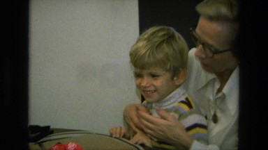 1975: grandma having family time with grandson showing photographs CALIFORNIA