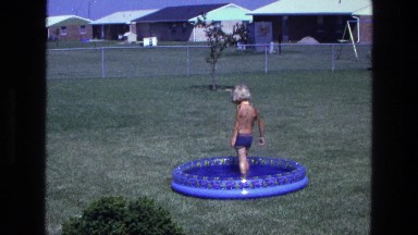 1975: a topless kid is seen pouring in a pool CALIFORNIA