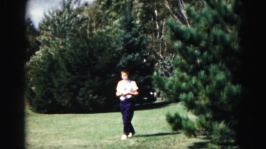 1962: Boy Wearing T-Shirt Walking Through Grass Field or Yard in Hagerstown, Maryland