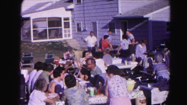 1962: a large number of people gather on a clear sunny day on benches