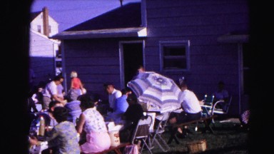 1962: a large group of people gathered on a clear and sunny day sitting on