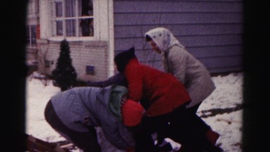 1962: four children building a snowman next to their house HAGERSTOWN, MARYLAND
