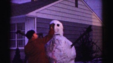 1962: teenage boy building a snowman in winter HAGERSTOWN, MARYLAND
