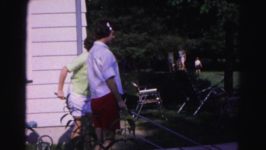 1962: two women outside with a shuffleboard sticks in their hands as they play