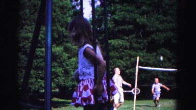1962: two kids balancing on a swing near to people playing badminton HAGERSTOWN