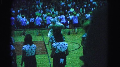 1962: people dancing and giving a show on a basketball court with spectators