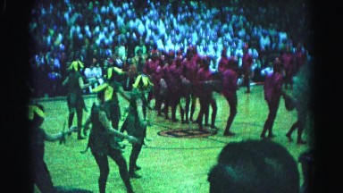 1962: kids in costume performing on a basketball court in front of an audience