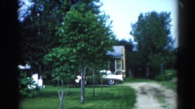 1962: a look of a neighborhood with their front yards and their cars parked out