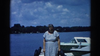1962: a lady stands at the dock with a boat nearby CHICAGOLAND AREA