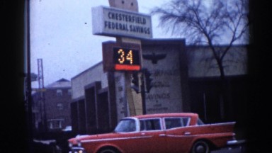 1962: the front of a bank with a light up sign stating the time and temperature.