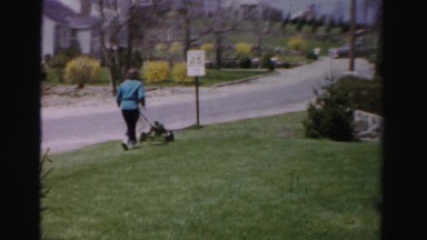 1956: woman mowing the grass