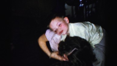 1956: two kids play with their father and mother stands nearby MADISON