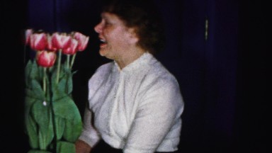 1956: a women making a weird face after having a smell of flower