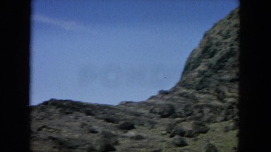 1964: a hilly area is seen with trees and greenery and water beside HAWAII