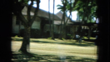 1964: large white building complex in the tropics with grounds and mountain.