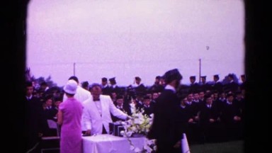 1966: a woman in pink outside shaking hands with graduates HAGERSTOWN, MARYLAND