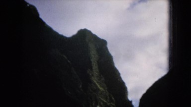 1964: a vehicle is moving nearby the mountain. HAWAII