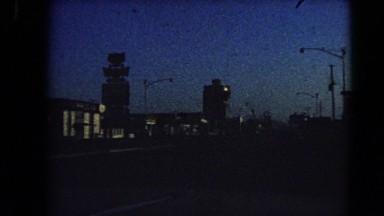 1966: driving down street in mid sized city during dusk BARSTOW, CALIFORNIA