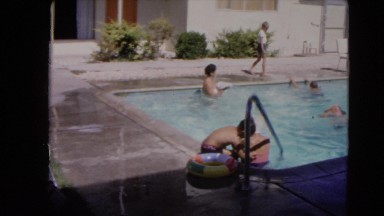 1966: young kids swimming and playing in the swimming pool on a sunny day