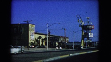 1966: a black kite flying in the sky above the road with many vehicles CATALINA