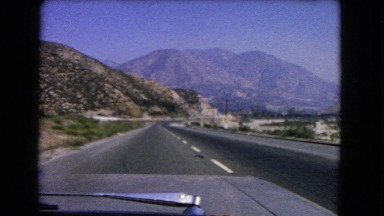 1966: alone on the highway driving fast towards perfect mountain view CATALINA