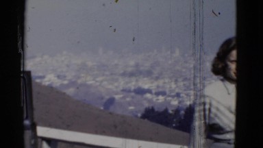 1952: a young woman on high altitude showing landscape of a city SAN FRANCISCO