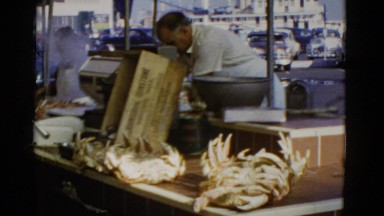 1952: a man standing in the open restaurant with dishes under preparation