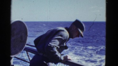 1952: ship on open sea, crew working, man leans over to look over the side SAN