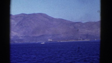 1952: a beautiful snow capped mountain ridge on a large body of water