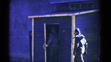 1952: men and women in military uniforms walking past a blue building