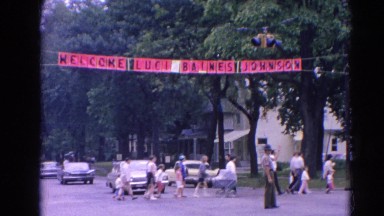 1964: a police officer directing traffic with a welcome sign hanging above