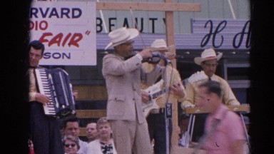 1964: a band is seen playing instruments in the open for people RACINE