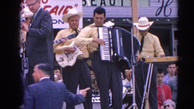 1964: a band is seen playing instruments in the open for people RACINE