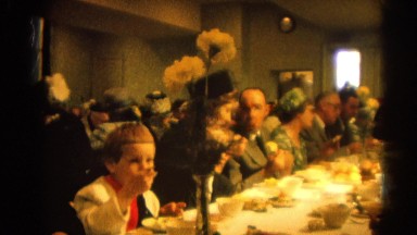 1964: various people gathered around a large table eating dinner RACINE