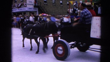 1964: riding a horse car buggy with five passengers and clown at parade
