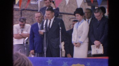 1964: a man is speaking in public. other people head down as he speaks.