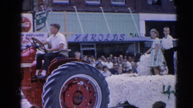 1964: tractor pulls 4-h float past spectators HARVARD, ILLINOIS
