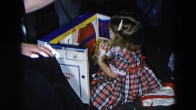 1956: girl playing with small toy kitchen next to grandpa HICKSVILLE, NEWYORK