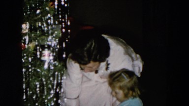 1956: a christmas tree is seen with a child opening presents HICKSVILLE, NEWYORK