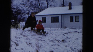 1956: sledding down a snowy hill HICKSVILLE, NEW YORK