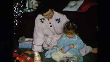 1956: mother and daughter opening presents HICKSVILLE, NEW YORK