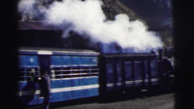 1962: Steam Engine with People Running to Board Open Train Cars